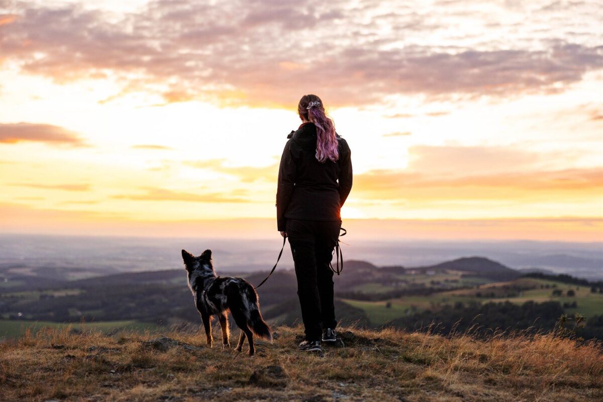 Silhouette von Mensch und Hund im Gegenlicht auf der Wasserkuppe
