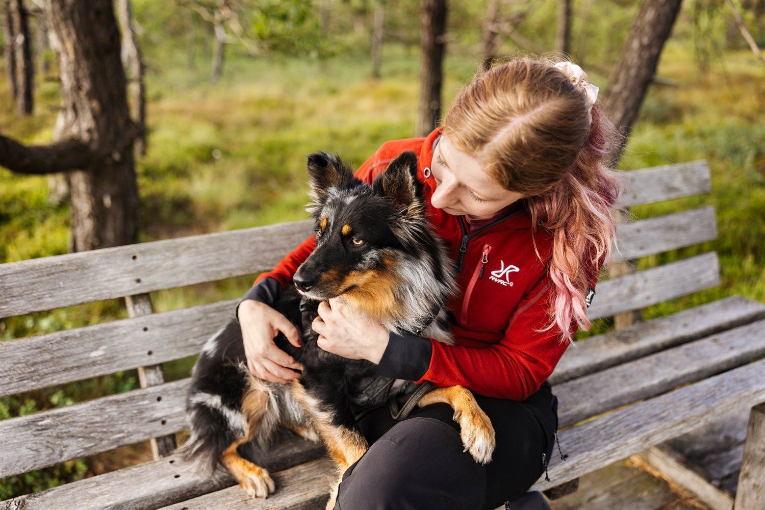 Hundebesitzerin streichelt ihren Hund während einer Fotowanderung im Schwarzen Moor in der Rhön
